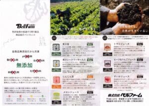 作物の画像、土を持つ手、さまざまな農産物とその説明を表示するテキストを含むパンフレット。ヘッダーには「ベルファーム」と書かれており、日本語のテキストで詳細が追加されています。注目の商品は、鮮度を重視した冷凍タイプの「青汁シークワーサー」30袋セットです。